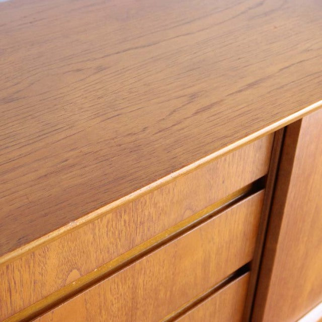 Close-up of vintage Jentique teak sideboard top and drawer fronts with fine wood grain and mid-century British design details.