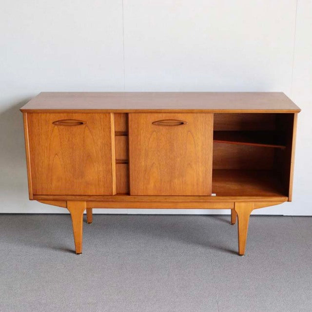 Mid-century British vintage teak sideboard by Jentique with sleek tapered legs and sliding doors showcasing warm wood grain.