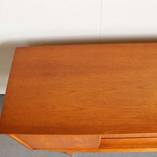 Compact mid-century teak sideboard by Jentique featuring warm wood grain and sleek British vintage design.