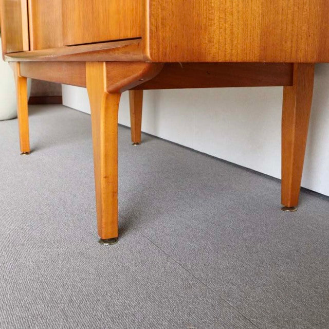 Mid-century British vintage teak sideboard by Jentique with slender tapered legs and visible wood grain.