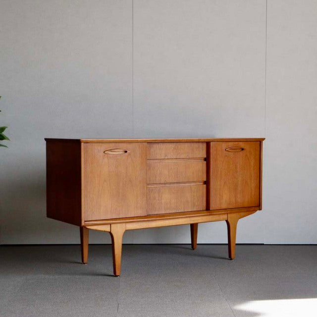Compact vintage teak sideboard by Jentique, British mid-century design with three central drawers and two cabinets, elegant.