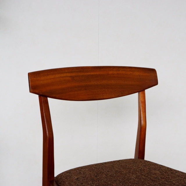 Vintage British mid-century teak dining chair by McIntosh with curved backrest and dark upholstered seat.