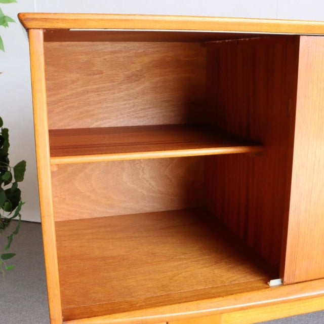 Compact Jentique British mid-century teak sideboard with smooth wood grain, adjustable shelf, and clean lines.