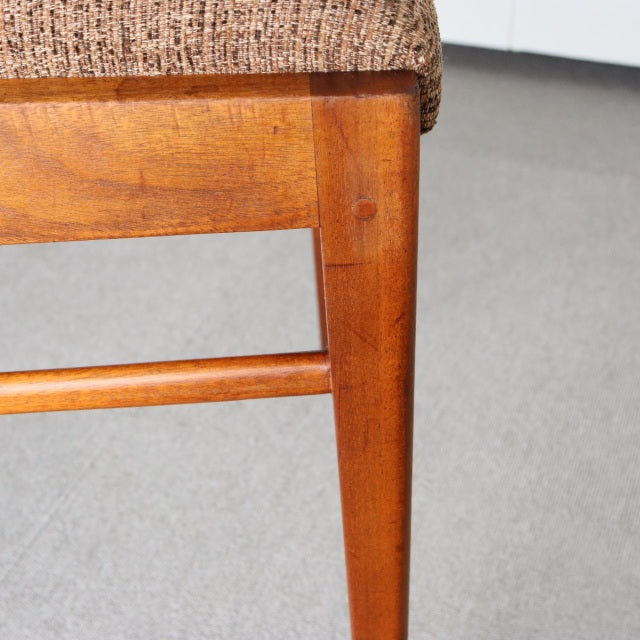 Mid-century British McIntosh dining chair leg in vintage teak with visible wood grain and brown fabric seat upholstery.
