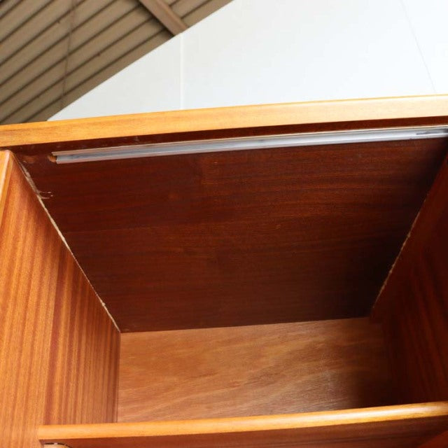 Open view of vintage British mid-century teak Jentique sideboard interior, showcasing rich wood grain and compact design.