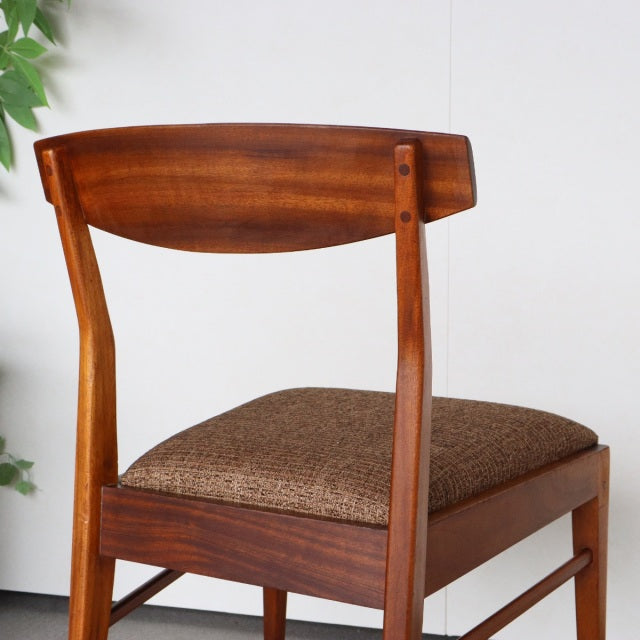 Vintage McIntosh mid-century teak dining chair from Denmark with curved backrest and textured brown upholstered seat.