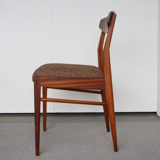 Mid-century British McIntosh dining chair in teak with warm wood grain and textured brown upholstered seat, slender tapered.