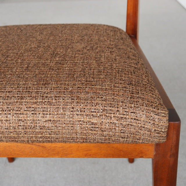 Vintage McIntosh teak dining chair with textured brown fabric seat, mid-century British design, sturdy wooden frame visible.