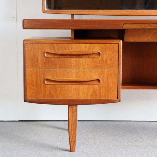 Mid-century British G-PLAN teak dresser drawer unit with sleek wood grain and tapered leg design.