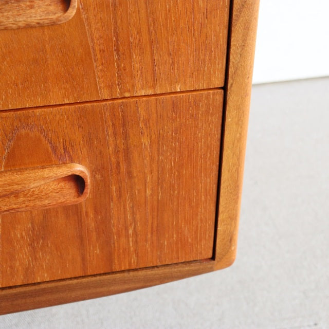 Close-up of vintage mid-century British G-PLAN teak dresser corner showing rich wood grain and rounded edges.