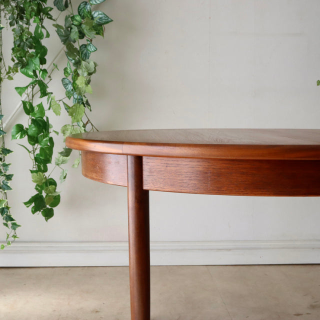 Vintage G-Plan teak dining table with rich wood grain, rounded edges, and mid-century British design legs, Scandinavian.