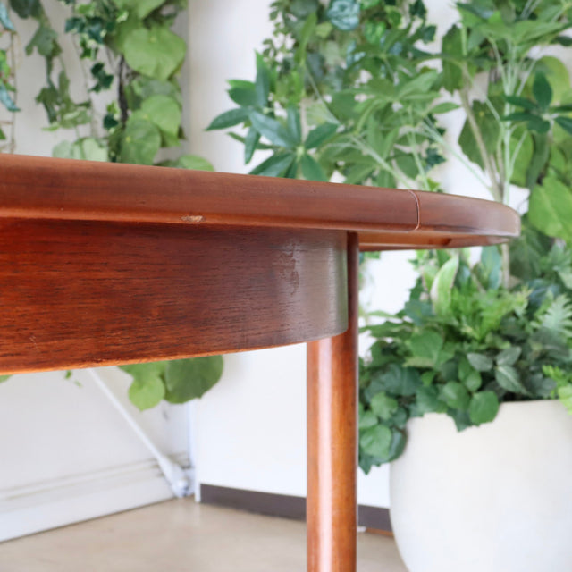 Mid-century vintage teak dining table by G-Plan, British design with smooth wood grain and slender tapered legs.
