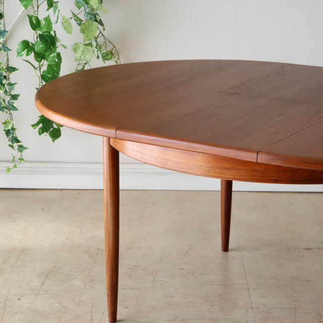 Vintage G-Plan teak dining table with rounded oval top and tapered mid-century British legs.