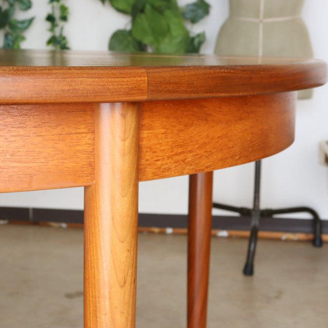 Mid-century British G-Plan vintage teak dining table with rounded edges and tapered legs showing warm wood grain.