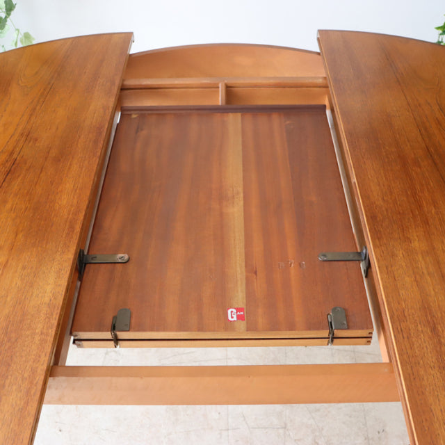 Vintage teak mid-century G-Plan dining table with rich wood grain, butterfly leaf extension, and slender tapered legs in.