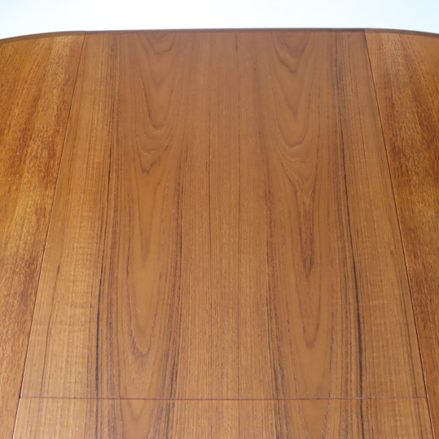 Mid-century British G-Plan dining table in vintage teak with smooth oval top and visible wood grain pattern.