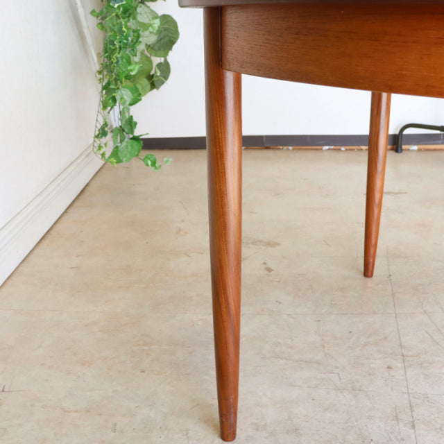 Close-up of vintage teak G-Plan dining table leg with smooth tapered mid-century British design and rich wood grain finish.