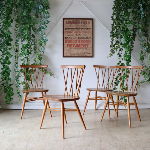 Set of two vintage British mid-century teak dining chairs by ERCOL, featuring one Hoopback chair with curved spindle.
