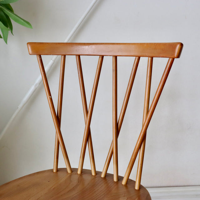 Vintage British mid-century ERCOL X-Back chair in teak with distinctive angled spindles and smooth wood grain finish.
