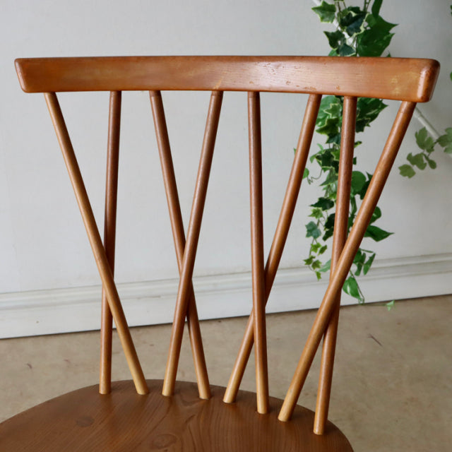 Vintage mid-century ERCOL X-Back chair crafted from warm teak wood with slender angled spindles and smooth rounded top rail.