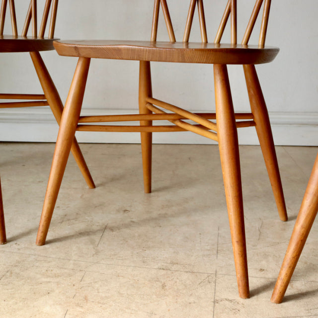 Vintage teak ERCOL X-Back chair with mid-century British design, showcasing slender spindle backrest and angled legs with.