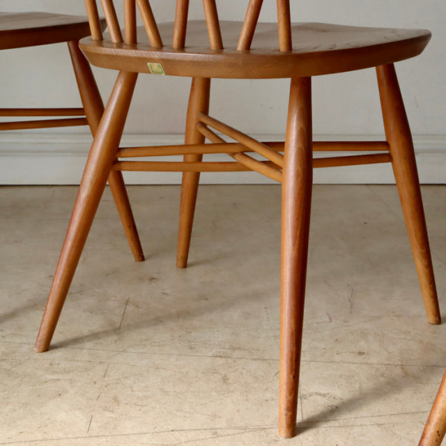Vintage teak Ercol X-Back chair with mid-century British design, smooth curved legs, and visible wood grain.