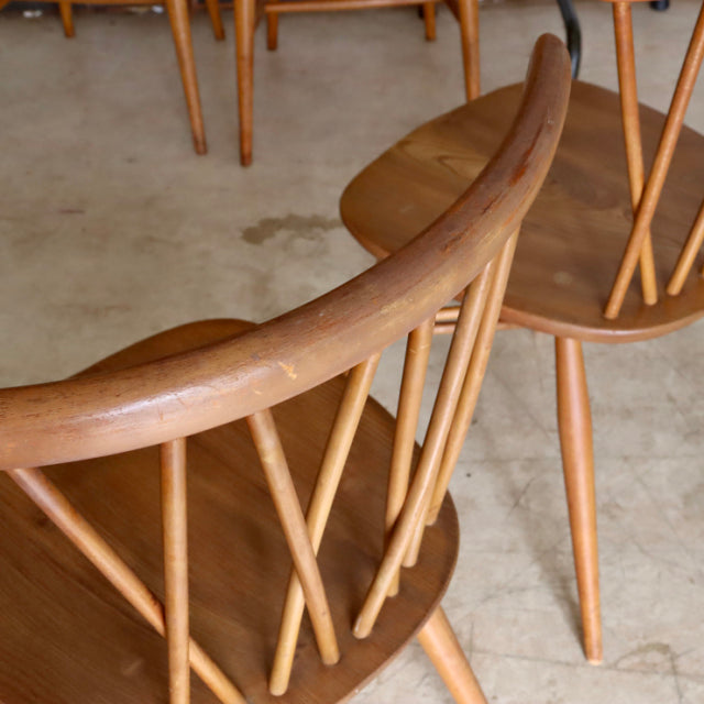 Vintage teak ERCOL X-Back chair with smooth curved backrest, slender spindles, and tapered legs in British mid-century.