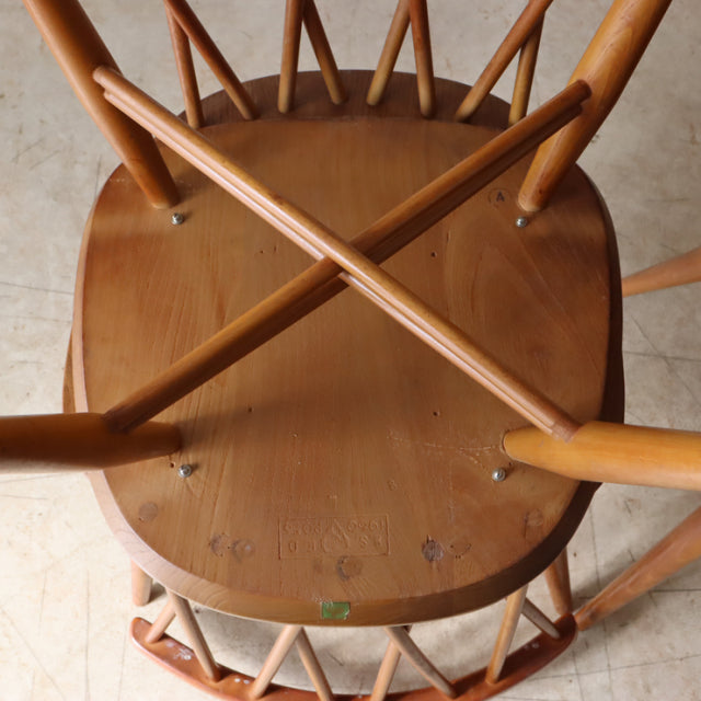 Vintage teak ERCOL X-Back chair seat with visible wood grain and crossed spindles, mid-century British design.