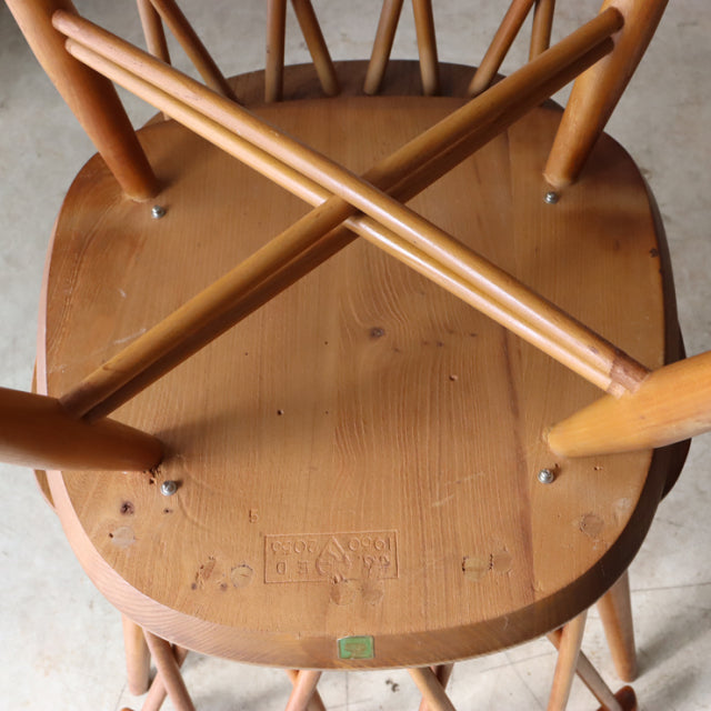 Vintage teak ERCOL X-Back chair viewed from below, showcasing British mid-century craftsmanship and wood grain details.