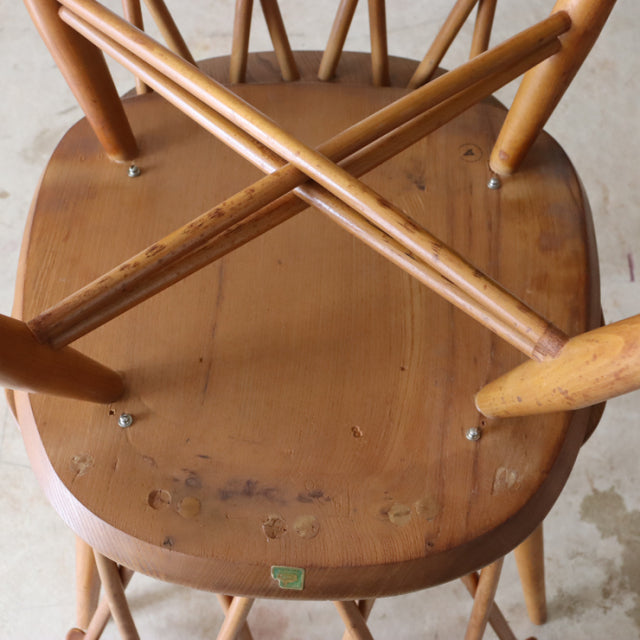 Vintage ERCOL X-Back chair in teak wood with smooth curved seat and crisscross spindled legs, British mid-century design.
