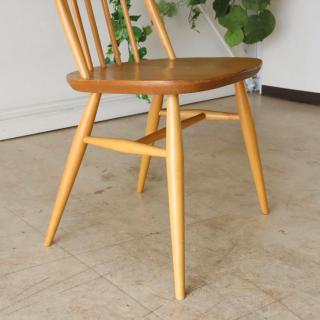 Mid-century British Ercol Quaker dining chair with teak seat, light wood spindle back and tapered legs, smooth grain finish.