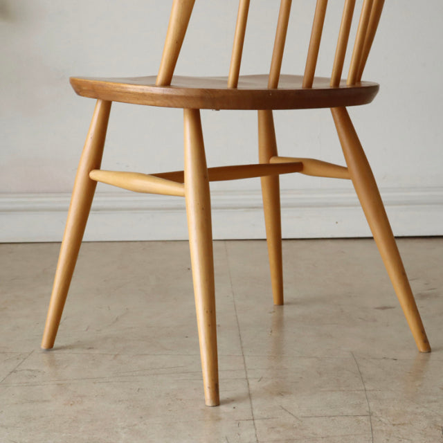 Mid-century British Ercol Quaker chair in vintage teak with smooth wood grain, spindle back, and tapered legs from Denmark.