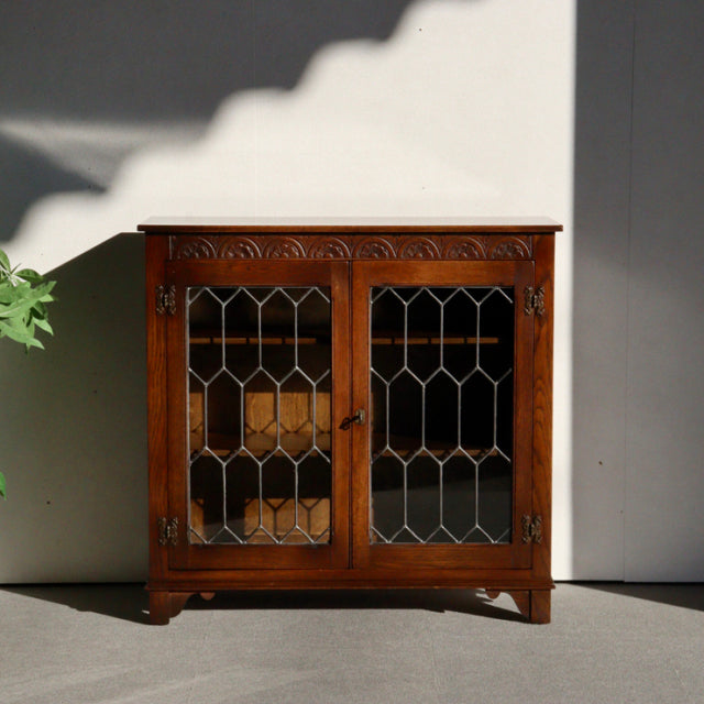 Vintage mid-century teak cabinet by Jaycee featuring British design with glass paneled doors and intricate wood grain.