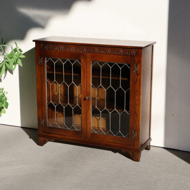Vintage teak Jaycee British mid-century cabinet with glass paneled doors and geometric leaded design.