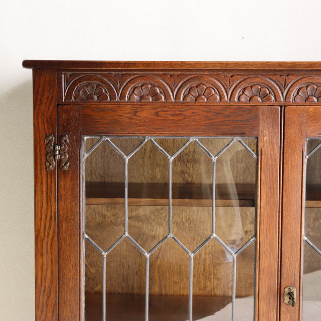 Vintage teak cabinet by British Jaycee, mid-century design with ornate carved top and leaded glass doors.