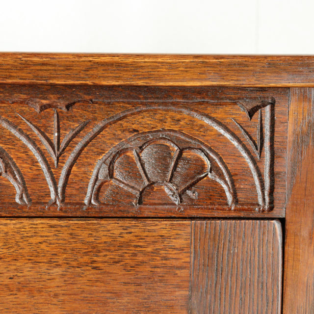 Close-up of vintage Jaycee teak cabinet corner with carved floral and arch details in mid-century British style.