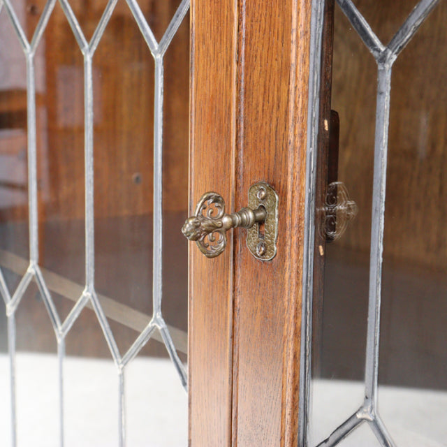 Mid-century vintage teak cabinet door with ornate brass latch, British Jaycee design, detailed wood grain and leaded glass.