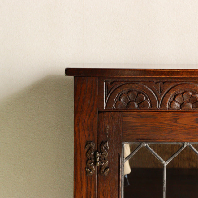 Mid-century British teak cabinet by Jaycee, detailed wood grain, carved floral panel, metal decorative hinge on rich wood.