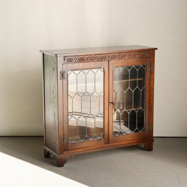 Vintage mid-century teak cabinet by Jaycee, British design with decorative glass doors and carved wood details.