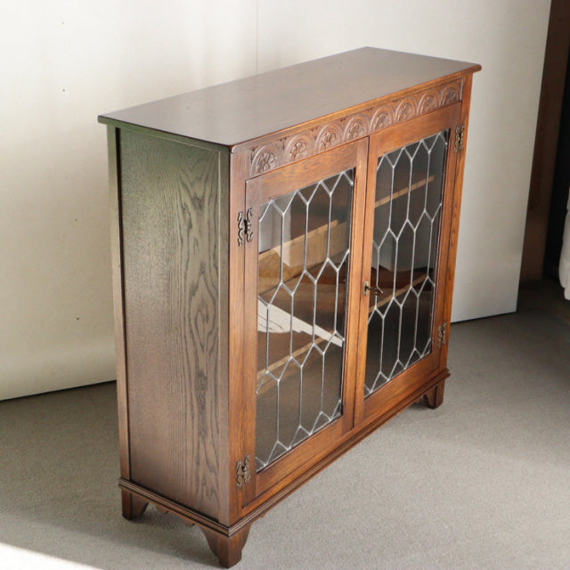 Vintage Jaycee teak cabinet with British mid-century design, glass paneled doors with geometric leaded patterns, and sturdy.