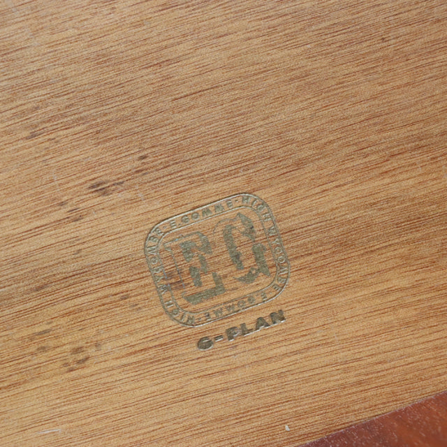 Close-up of vintage British G-Plan teak wood showing clear mid-century grain and G-Plan brand stamp.