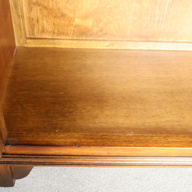 Close-up of vintage teak wood cabinet shelf showing warm grain and smooth mid-century finish.