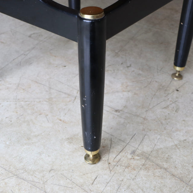 Black tapered wooden leg with brass cap and caster on mid-century British teak G-PLAN bedside cabinet.