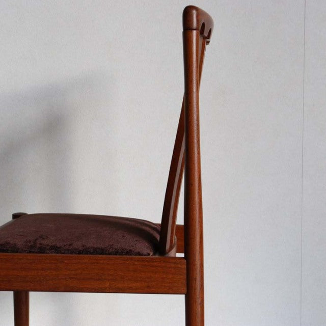 Mid-century British Meredew teak dining chair with slender vertical backrest and polished wood grain.