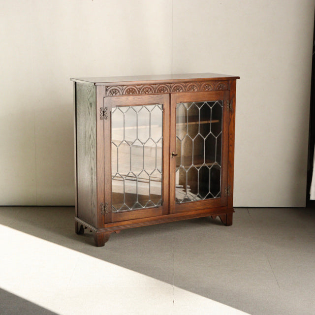 Vintage British Jaycee teak cabinet with mid-century Danish design, glass-paneled doors, intricate wood grain, and short.