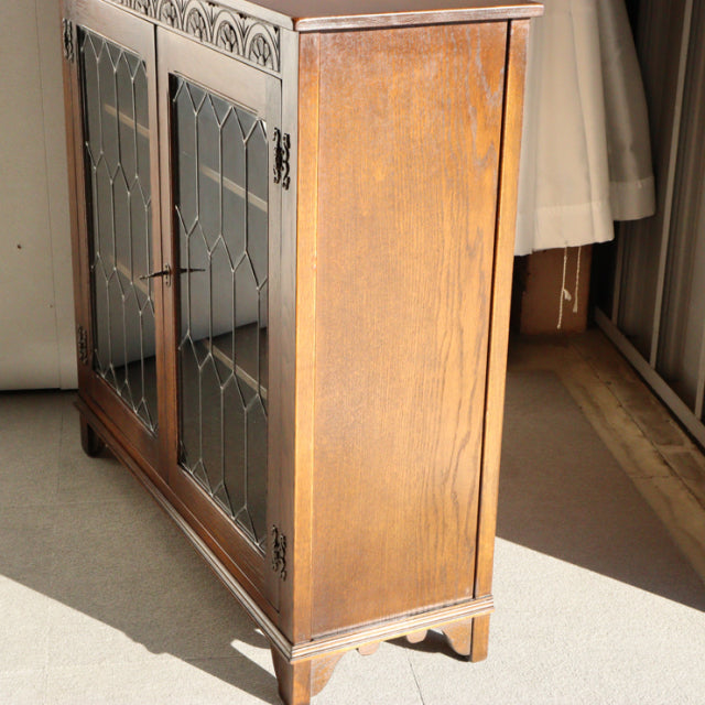 Vintage teak cabinet by Jaycee featuring British mid-century design, decorative glass doors, and carved wood legs.