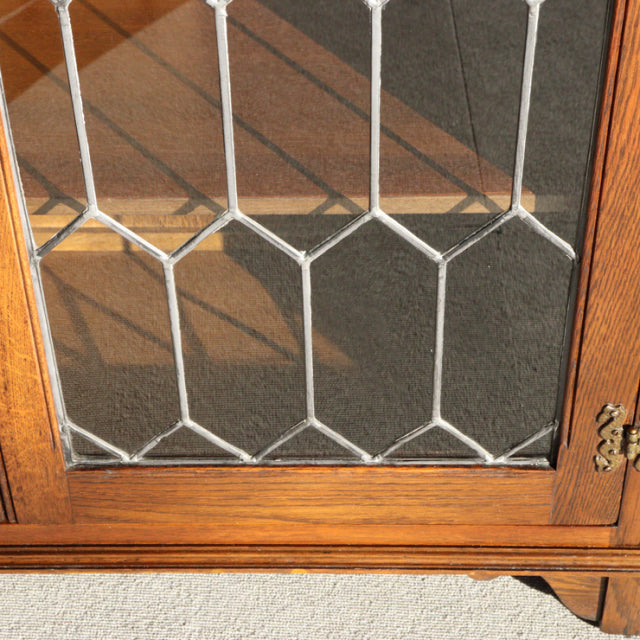 Mid-century British vintage teak cabinet door with geometric leaded glass and visible wood grain detailing.