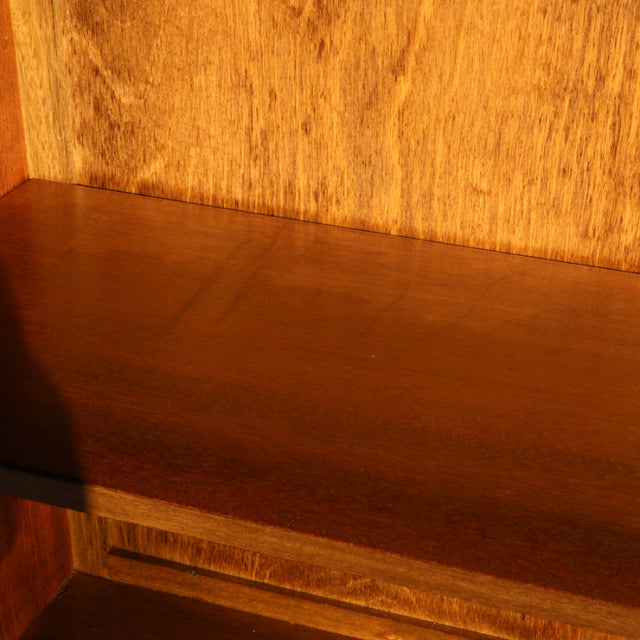 Close-up of vintage mid-century teak wood cabinet shelf showing rich wood grain and smooth finish.