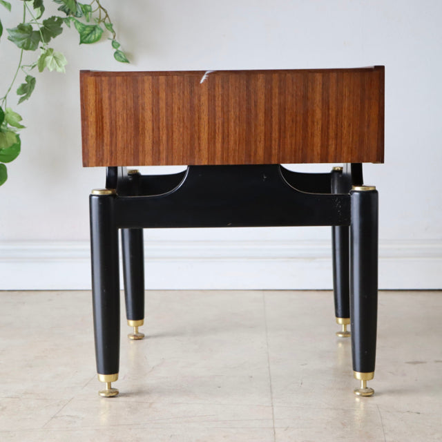 Vintage British mid-century G-Plan bedside cabinet in teak with black legs and brass feet accents.