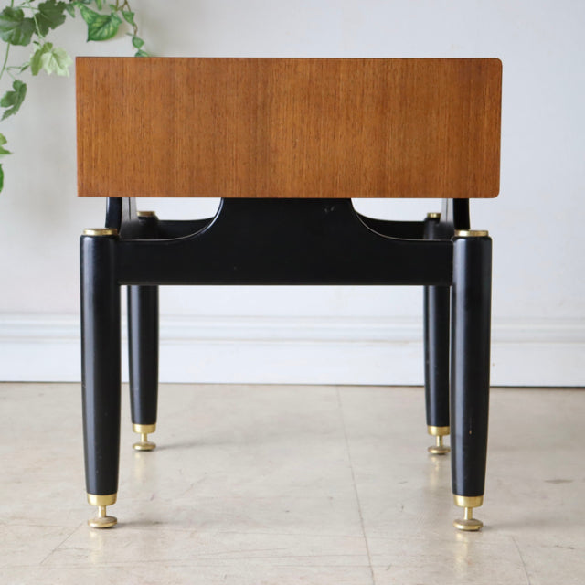 Vintage British G-Plan teak bedside cabinet with black tapered legs and brass feet, mid-century Denmark design.
